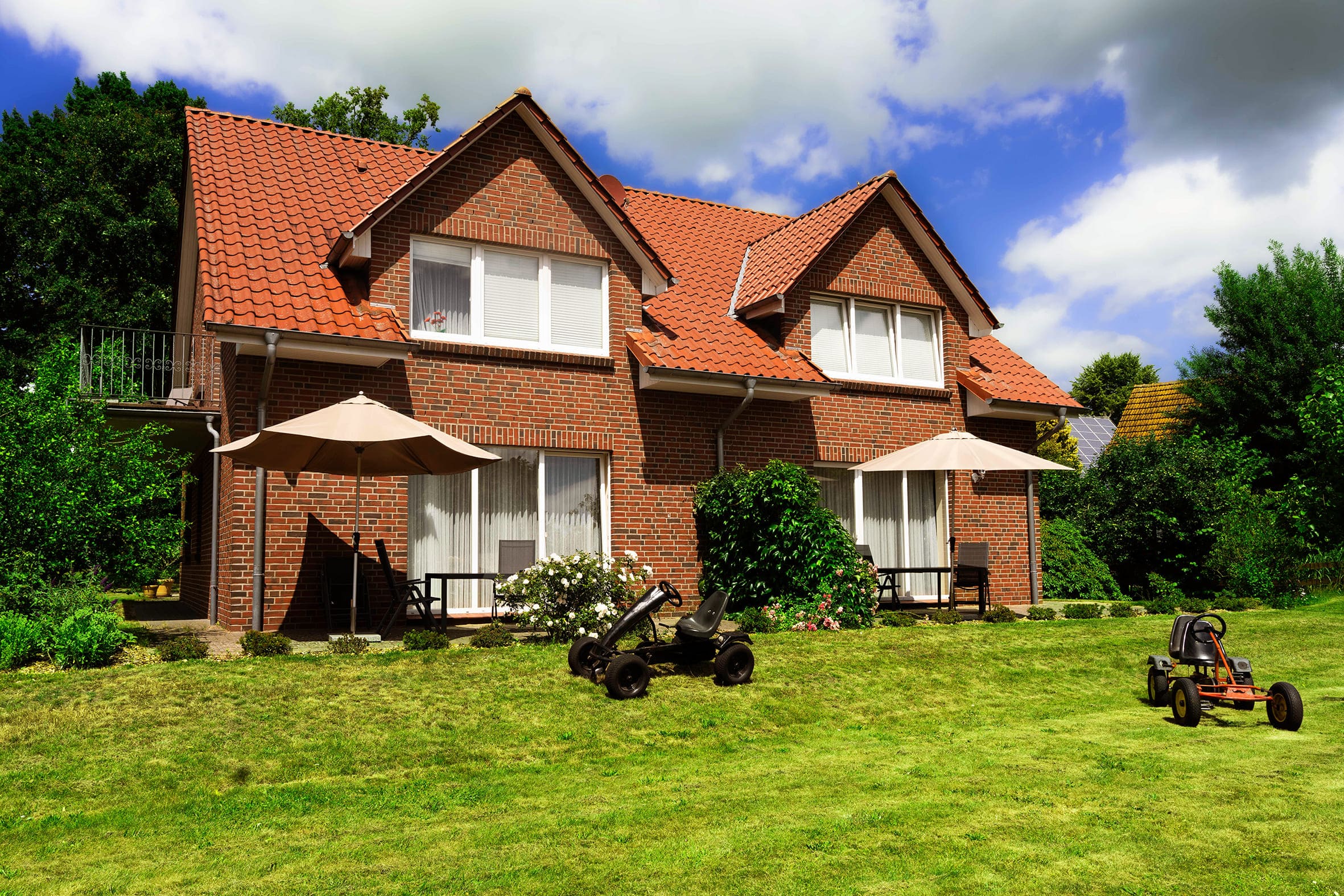 Hausansicht Längsseite mit Terrasse und Garten